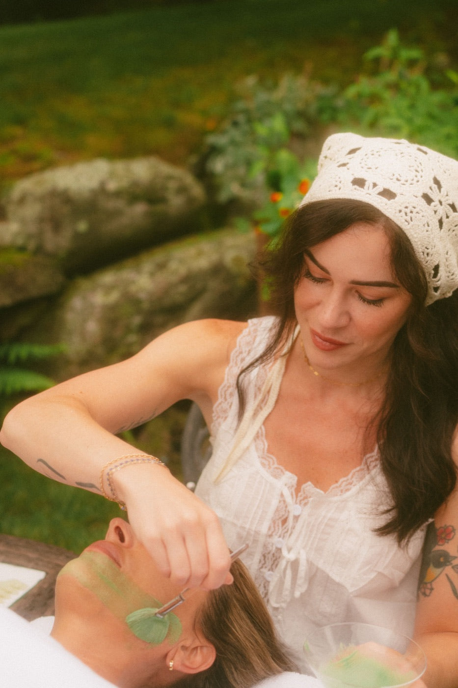 Kristen Kane applying a facial mask outdoors