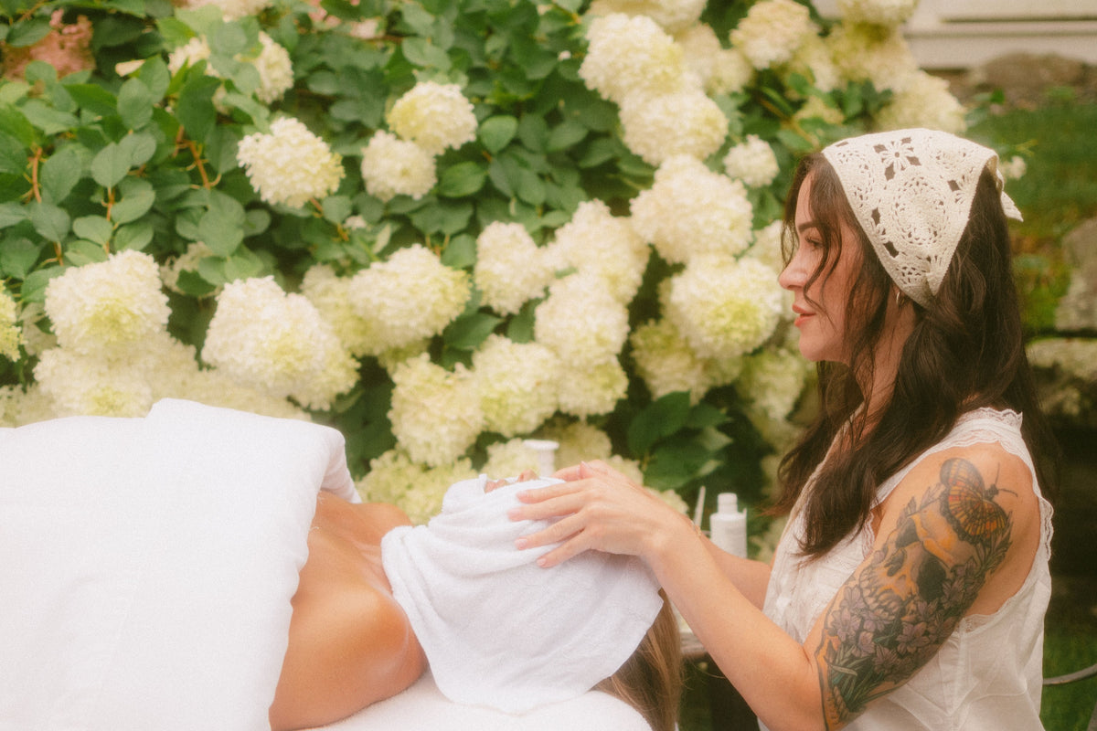 Kristen Kane giving a facial in a garden of white hydrangeas, Level Aesthetics, New Windsor NY